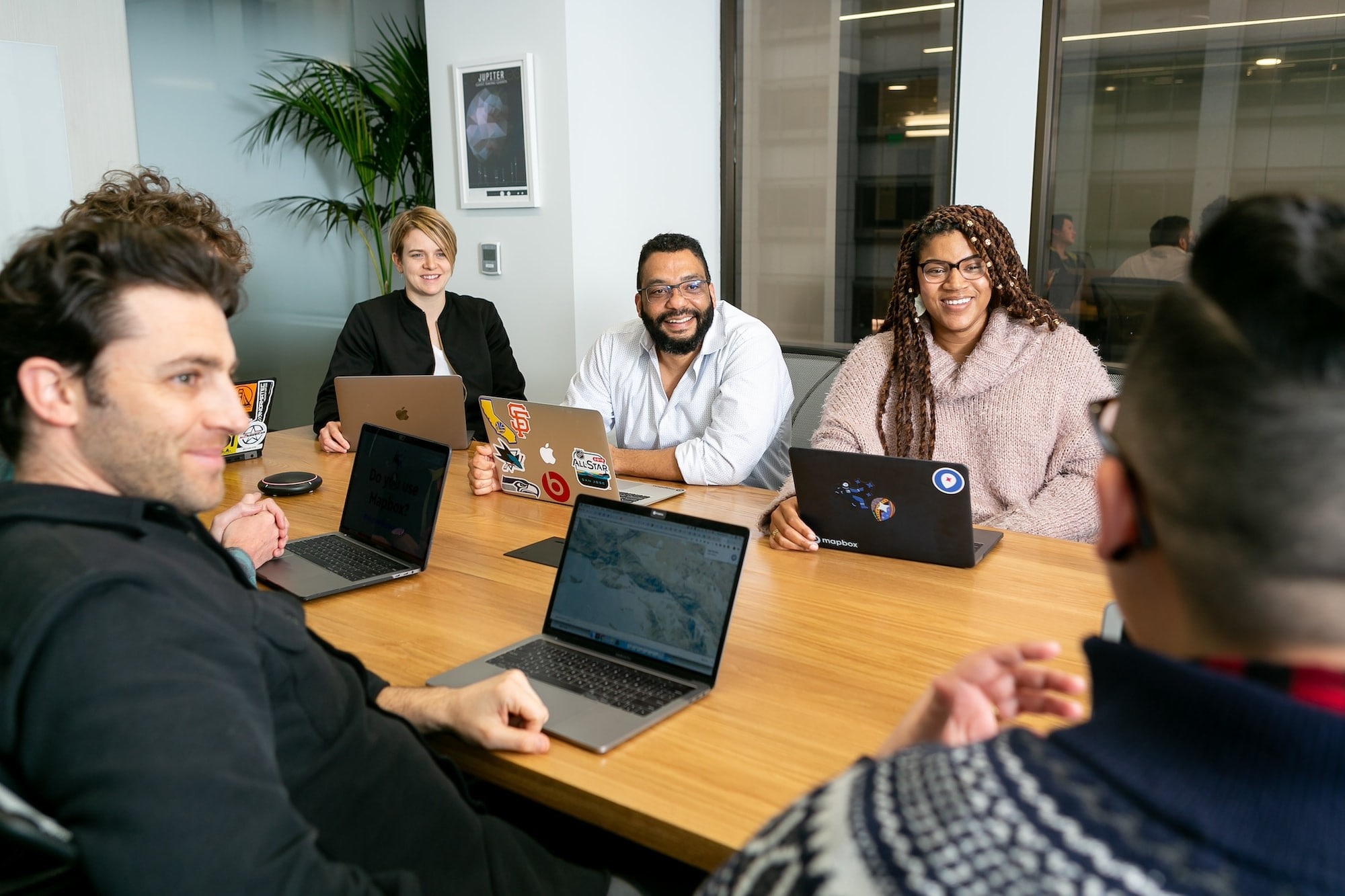 A group of people smiling at someone who is speaking during a meeting.